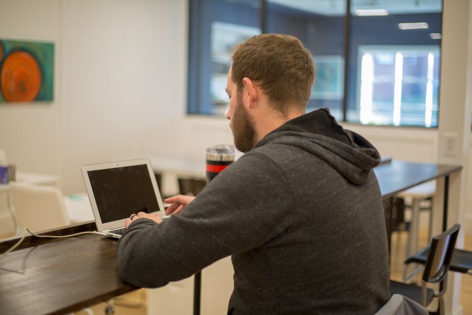 An employee working at a laptop in a bright office